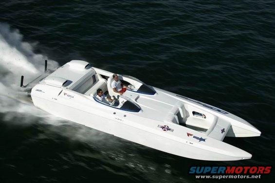 White performance boat with two people onboard speeding through dark water
