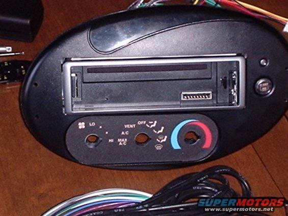 Car radio and climate control panel with visible text labels for fan speed and air conditioning settings