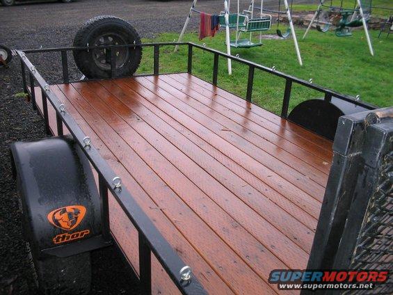 Trailer with wooden deck and spare tire mounted on the side
