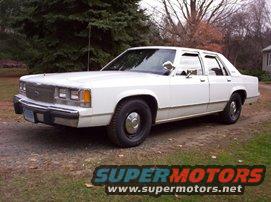 White 1980s Ford sedan, 3/4 front view