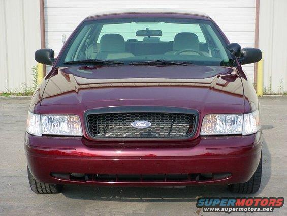 Front view of a maroon 2004 Ford Crown Victoria parked in front of a garage