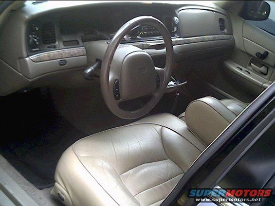 Tan leather interior of a 1999 Ford Crown Victoria, showing dashboard and seats