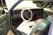 1985 Ford Crown Victoria LTD - Interior view of a green car, a white steering wheel cover and plush seat covers.