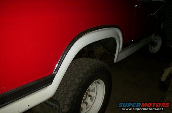 Red SUV side view, showing fender flare and tire