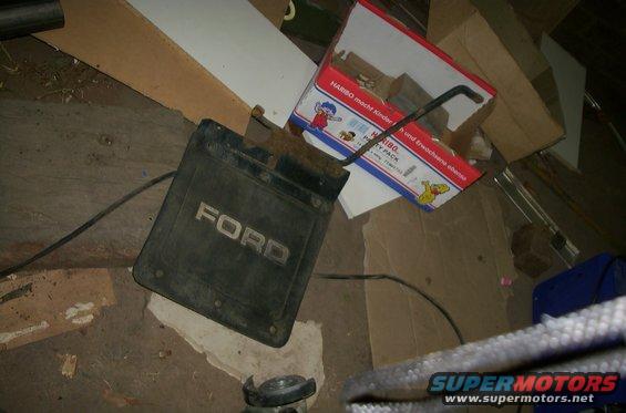 Ford mud flap on the ground next to boxes