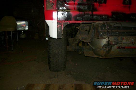 1981 Ford Bronco rear quarter panel, red and white paint, off-road tire