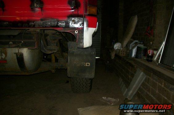 Rear fender and mud flap on a Ford Bronco. Some rust repair is visible on the body