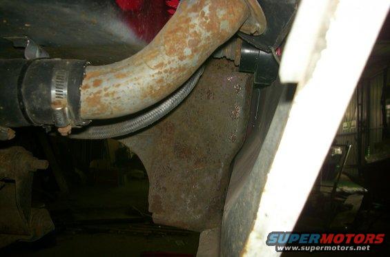rusted metal pipe held by hose clamp, part of vehicle undercarriage