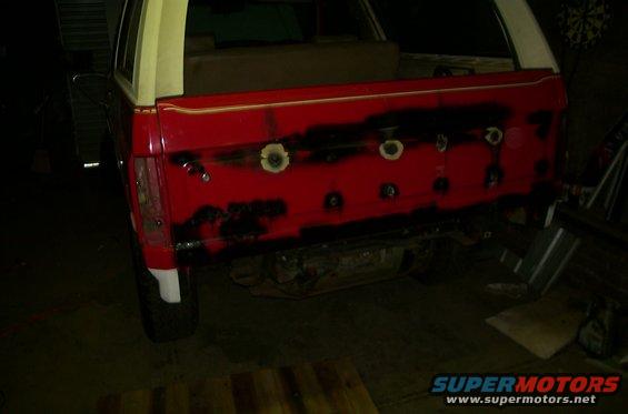 1981 Ford Bronco rear gate being prepped for paint, showing red primer and black primer spots