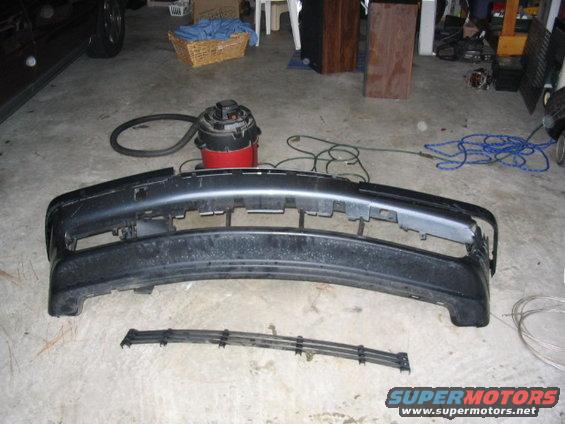 Black front bumper and grille assembly on concrete floor