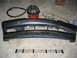 1995 Ford Taurus - A dark gray bumper and grille assembly are laid out on a concrete floor, with a shop vacuum visible behind them.