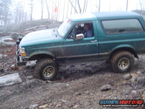 Green 1993 Ford Bronco navigating rocky terrain