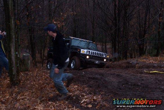 Black Hummer H2 off-roading in muddy woods