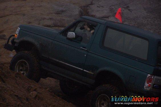 Green Ford Bronco climbing rocks, red flag on roof. Date stamp 11/20/2004