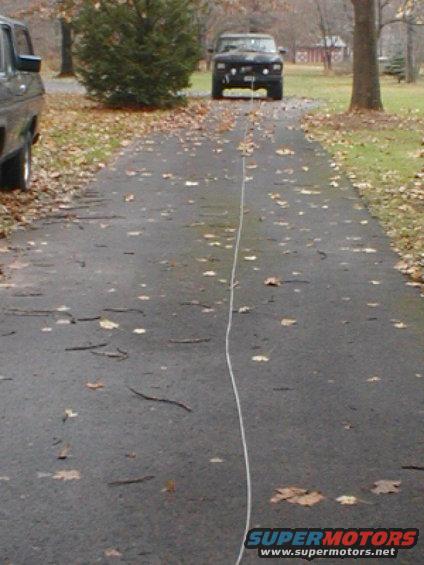 1970s Ford F-Series truck and another truck on a leaf-covered driveway