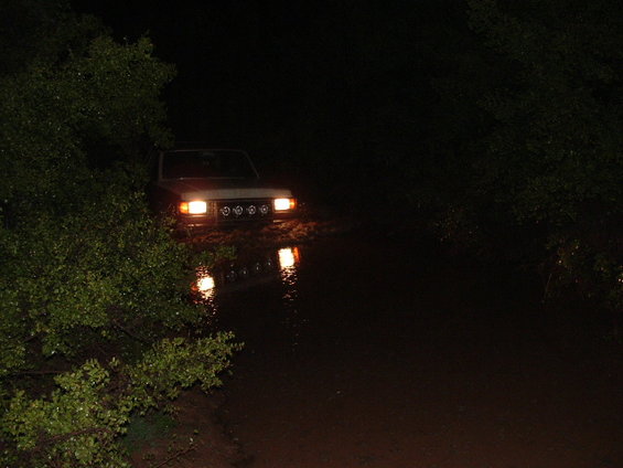 1990 Ford Bronco front view driving through water at night