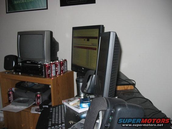 Computer monitors, keyboard, and Dr. Thunder cans on a wooden stand