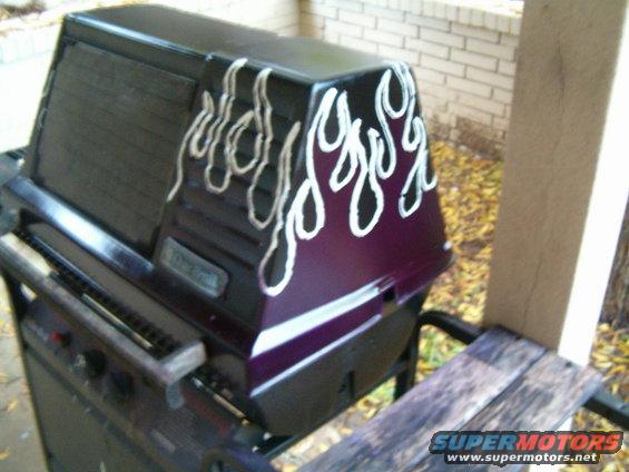 gas grill with purple and black paint, white flame decals, and a metal grate