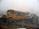 1979 Ford Bronco - A yellow school bus and a modified pickup truck are seen side-by-side in foggy weather.