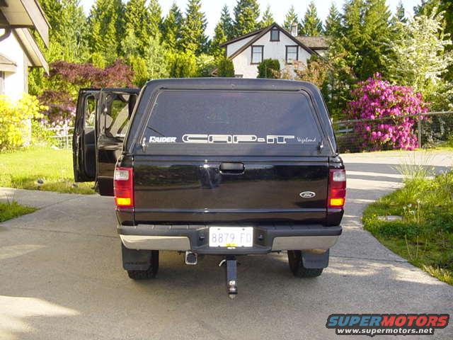 Rear view of a black Ford Ranger pickup with a camper shell. License plate reads 8879 FD