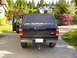 2003 Ford Ranger - This black Ford Ranger pickup truck is parked in a driveway with a house and trees in the background.