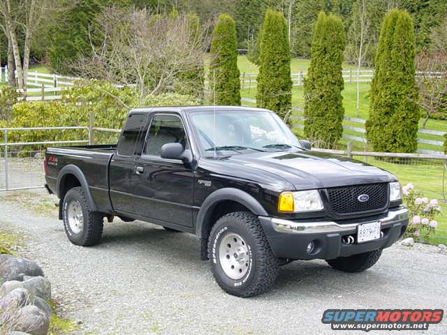 Black 2003 Ford Ranger pickup truck parked on a gravel driveway, front 3/4 view