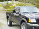 2003 Ford Ranger - Black 2003 Ford Ranger pickup truck seen from the front quarter angle.