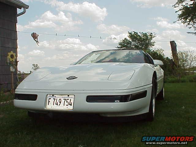 White 1994 Chevrolet Corvette with a license plate reading F 749 754 parked on grass
