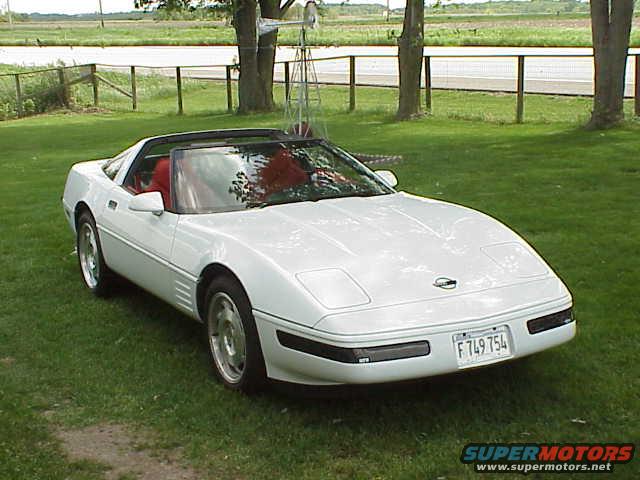 White 1994 Chevrolet Corvette convertible with red interior parked on grass