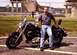 1989 Ford Bronco - A man poses with his motorcycle in front of a fence and bridge.