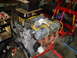 1981 Ford Bronco - An engine is mounted on a stand in a workshop, with a go-kart frame visible in the background.