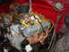 1981 Ford Bronco - Engine assembly being lifted, showing spark plug wires and oil filter.