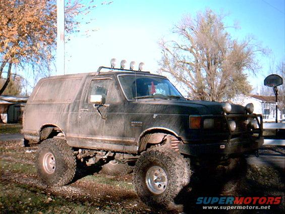 1990 Ford Bronco 3q-front view, black with off-road tires and roof lights