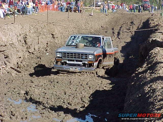 1987 Ford Ranger driving through a mud pit with spectators in the background