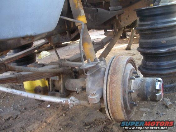 Front axle assembly with leaf springs and shock absorber