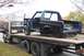 1989 Ford Bronco - A partially disassembled truck is being transported on a flatbed trailer, with another vehicle visible behind it.