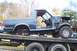 1989 Ford Bronco - 1989 Ford Bronco body being transported on a flatbed truck, stripped of many parts.