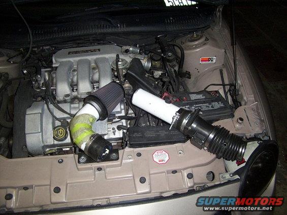 Engine bay of a 1998 Mercury Sable with an aftermarket air intake system installed