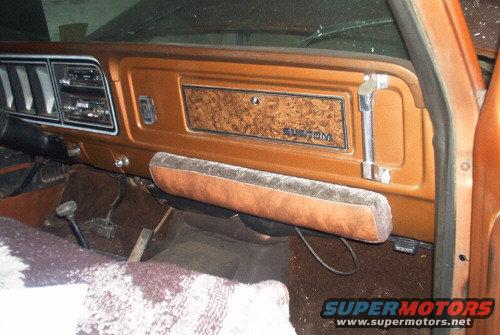 1978 Ford Bronco interior dash with woodgrain trim and "CUSTOM" badge, showing radio and vents
