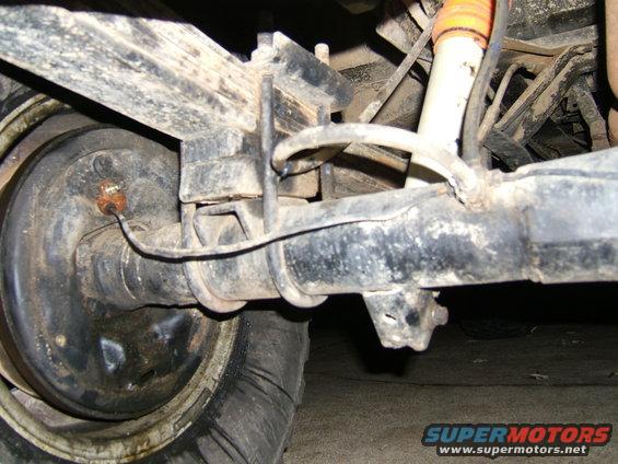 close-up of vehicle's rear axle, leaf springs, and shock absorber