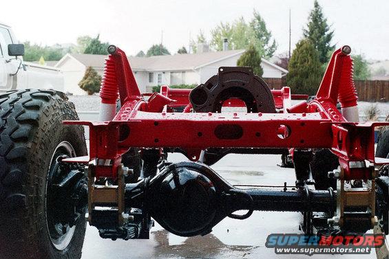Red painted vehicle frame with suspension components and large tire