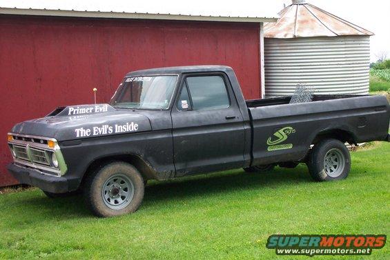 1977 Ford F-150 pickup truck with custom hood scoop and decals parked on grass
