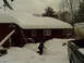 2000 Ford Mustang - A person walks through deep snow near a house, with a truck and trailer visible.
