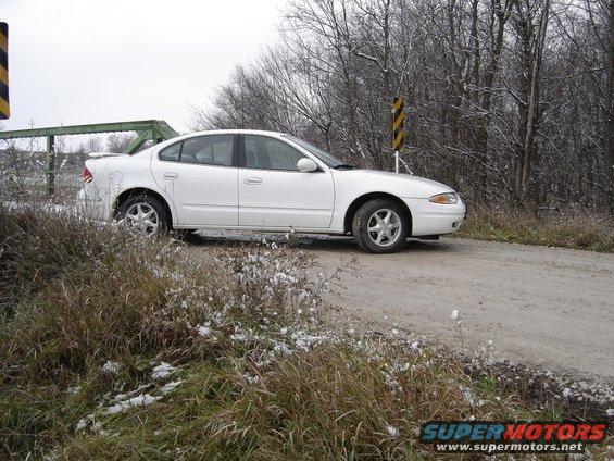 White 1999 Oldsmobile Alero sedan parked on a dirt road
