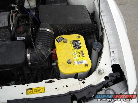 Engine bay with yellow Optima battery and air intake hose