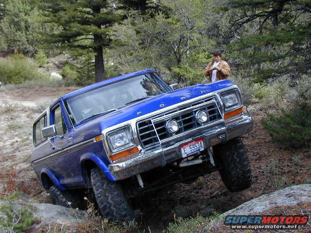 Blue 1978 Ford Bronco off-roading on a rocky trail