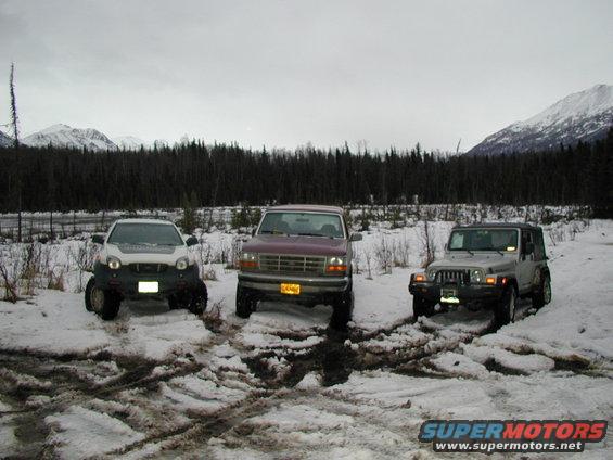 White 2001 Isuzu Vehicross in front, maroon Ford F-150 in middle, silver Jeep Wrangler on right, all in snow