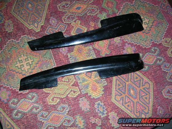 two black plastic trim pieces on a patterned rug