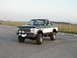 1994 Ford Bronco - This lifted Ford F-Series pickup has a two-tone paint scheme and auxiliary lights on the front bumper.