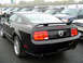1979 Ford Bronco - A black Ford Mustang coupe is parked in a lot with other vehicles.